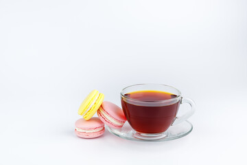 Cup of tea and colorful macaroons on a white background.