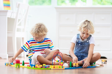 Kids play wooden railway. Child with toy train.