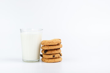 A glass of milk and cookies with raisins on a white background