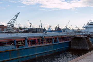 View on the cargo side port in Saint-Petersburg from the Neva river on the summer evening