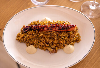 Un delicioso plato gourmet de arroz con tentaculo de pulpo en un restaurante europeo marítimo de lujo