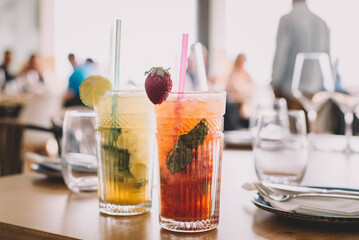 Dos cocktails de mojito hecho con ron añejo, menta, y diferentes frutas. Uno de fresa y el otro de...