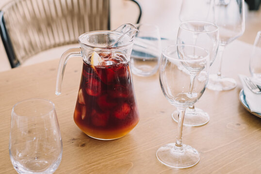Jarra de litro de sangr&iacute;a hecha con vino tinto y zumos frutales, con dos copas en un restaurante
