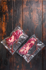  Vacuum packed Chuck roll  beef steak on dark old wooden background, top view with space for text.