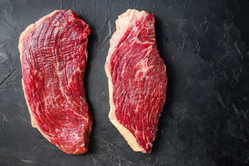 Set of picanha raw beef steaks on black textured background, top view space for text.