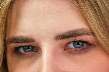 Close up blue eyes of an attractive blond girl.