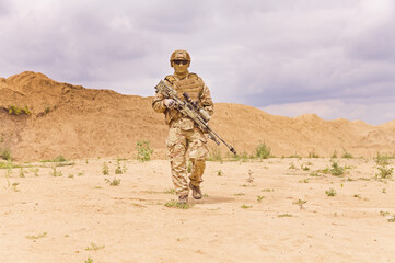 Fully equipped and armed special forces soldier in the desert, army anti-terror missions concept.