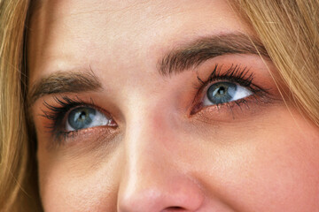 Woman's blue eyes look left and up.