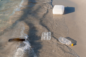 Waste floating on the sea water in the shore. Empty bottles and plastic. Pollution problems