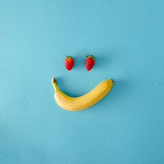 Optimistic spring arraignment. Strawberries and banana on a pastel blue background. Minimal...