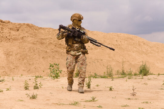 Equipped and armed special forces soldier with rifle in the desert.
