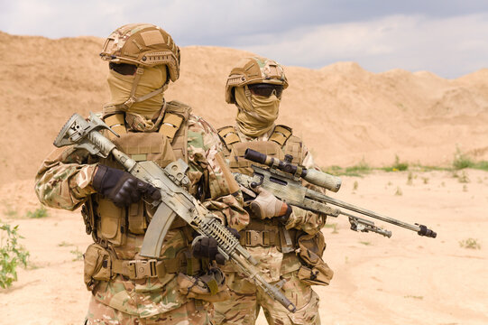 Two equipped and armed special forces soldiers with rifles in the desert