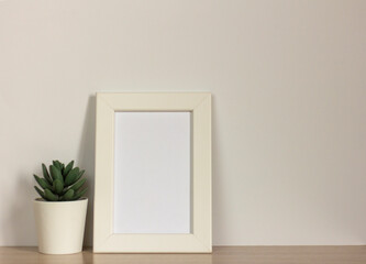 An empty photo frame on a table or shelf with a copy of the space.