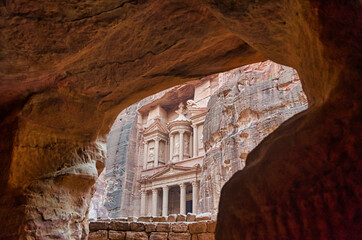 Facade of the famous Treasury or al Khazna in the ancient Nabatean city of Petra viewed from inside a carved cave