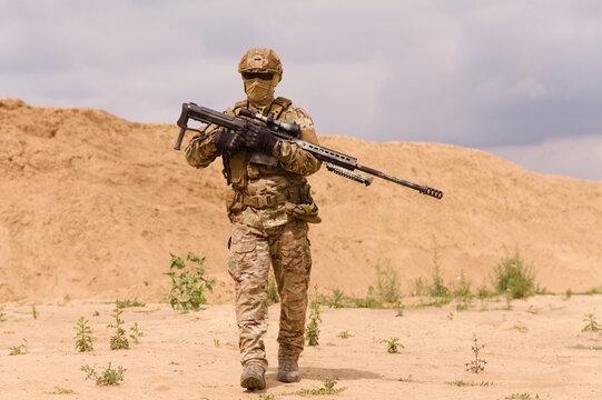 Armed special forces soldier with rifle in the desert during the military operation. Concept of military anti-terrorism operations, special operations of NATO forces.