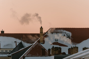 smoke of chimneys on rooftop in city