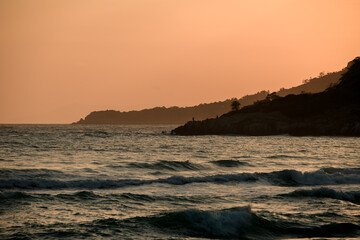 magnificent hill landscape with view of mountains and ocean and sunny sunset