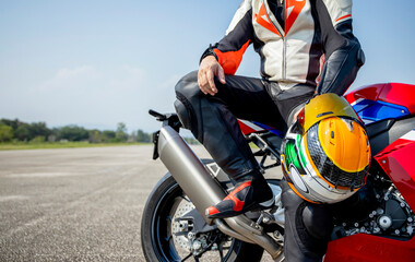 rider motorbike holding his motorcycle helmet sitting on a big bike in the road riding with soft-focus and over light in the background