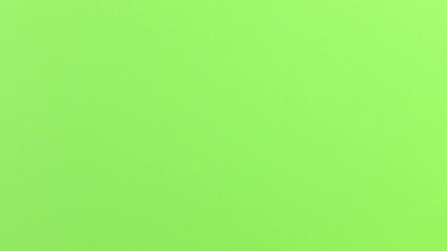Stop Motion Animation_Green paper ball unwrapping on orange background_Green screen