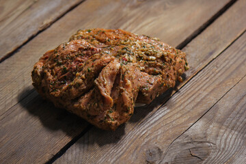 a piece of baked meat on the grill with spices lies on a wooden background close-up. Beautiful delicious fried steak ready to eat