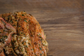 a piece of baked meat on the grill with spices lies on a wooden background close-up. Beautiful delicious fried steak ready to eat