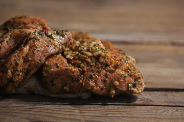 a piece of baked meat on the grill with spices lies on a wooden background close-up. Beautiful delicious fried steak ready to eat