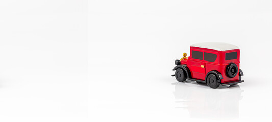 Miniature toy red retro car on white background. Metal model.,A red toy car on a white background