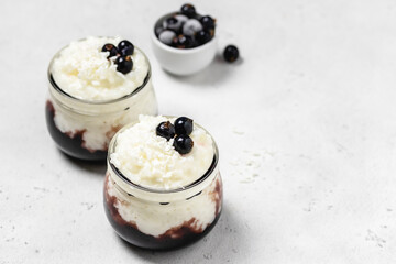 Vegan crockpot rice pudding with berries  in glass jars. Space for text.