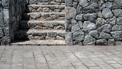 Gray granite stone wall and granite staircase in the park.