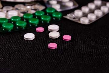 Antibiotic pills on a black background. Healthcare and medicine concept