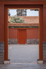 The ancient buildings with red wall, yellow or gray tile roof, door gate in the Forbidden City, Beijing, China