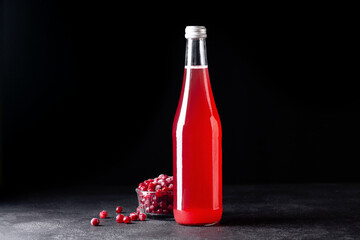 cranberry juice in a glass bottle on a black stone background, cranberry berries © Анастасия Коровина