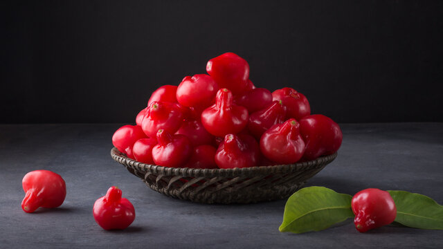 jambu or rose apple, bell-like shape fruit also called bell fruit or wax apple, sri lanka juicy fruits in a basket, taken on dark background