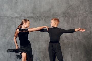 Young couple little boy and girl dancing in ballroom dance Jive. - obrazy, fototapety, plakaty