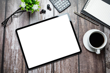 Tablet with a blank screen and an office device on a wooden table. Mock up.