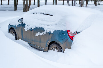 Parking of cars covered with snow. Heavy snowfall covered the road. Car in the snow