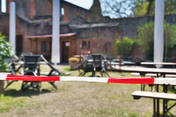 Barrier tape blocking off closed beer garden restaurant during Corona Virus lockdown