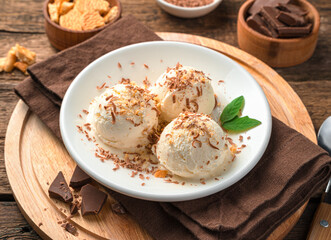 Creamy ice cream with chocolate chips on a white plate.