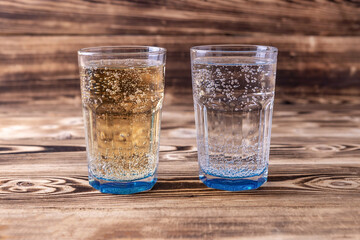 two glasses of fresh seltzer water on a wooden background