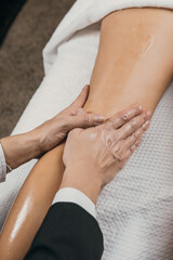 Leg massage with oil. Close-up of hands applying pressure. Stimulation of the lymphatic system to improve circulation and the elimination of toxins.