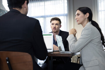Three Causasian Businespeople  in a Serious Meeting