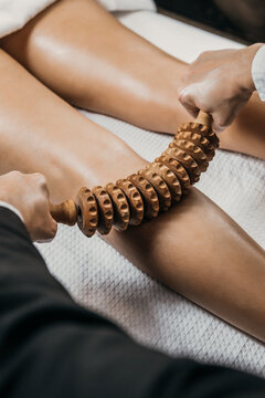 Stimulation of the lymphatic system with wood therapy body treatment. Massage with wooden roller to eliminate liquids and cellulite. Improve circulation in the legs. Aesthetic tools 