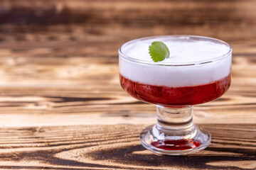 vanilla panna cotta with strawberry jelly and mint leaf on a wooden background. home cooking