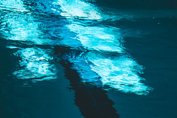a water pool with blue transparent clear water, on which bright sunlight shines. Water lanes in the swimming pool. indoor sports field for swimming
