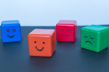 Different emotions concept, funny faces drawn on cubes.