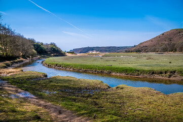 A view across Pennard Pill stream towards Three Cliffs Bay, Gower Peninsula, Swansea, South Wales on a sunny day