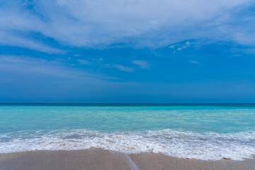 Fototapeta na wymiar Turquoise sea, gray sand, blue sky. Ocean vacation concept