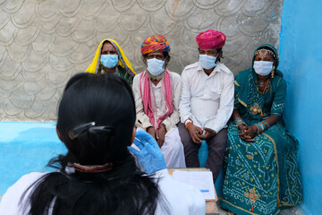 Group of Indian people receiving safety instructions from a doctor during the COVID-19 pandemic