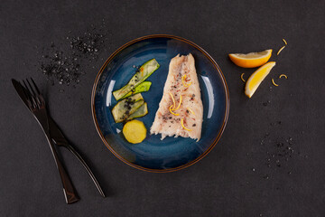Luxurious seafood dinner. Perch fish fillet with vegetable on black.
