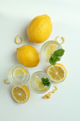 Shots of vodka and lemons on white background